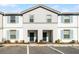 Two-story townhome with gray siding, blue shutters, and a two-car driveway at 7420 Oakmoss Loop, Davenport, FL 33837