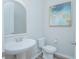 Powder room featuring a pedestal sink, modern toilet, and decorative mirror at 840 Livestock Loop, St Cloud, FL 34771