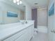 Bathroom with white vanity, gray tiled shower, and decorative wall art at 840 Livestock Loop, St Cloud, FL 34771