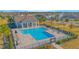 Community pool with a pool house surrounded by a paved patio area and chaise lounges at 840 Livestock Loop, St Cloud, FL 34771