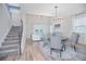 Open-concept dining area with a staircase, wood-look flooring, and a view of the living room at 840 Livestock Loop, St Cloud, FL 34771