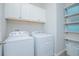 Laundry room with white Whirlpool washer and dryer and overhead cabinetry at 840 Livestock Loop, St Cloud, FL 34771