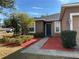 Front entry of a house with a dark-colored door and red mulch landscaping at 146 Prairie Falcon Dr, Groveland, FL 34736