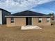 Rear view of house with solar panels and a patio at 146 Prairie Falcon Dr, Groveland, FL 34736