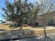 House exterior showcasing a brown one-story home with a yard and trees at 146 Prairie Falcon Dr, Groveland, FL 34736