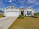 One-story home with a two-car garage and landscaping at 2030 Ficus St, Mascotte, FL 34753