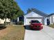 Cute one-story house with a two-car garage and a manicured lawn at 209 Curtis Ave, Groveland, FL 34736