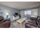 Bright living room with ocean view, comfy leather sofas, and a coffee table at 4155 S Atlantic Ave # 210, New Smyrna Beach, FL 32169