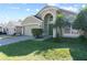 Green house with palm trees, two-car garage, and a manicured lawn at 422 Troon Cir, Davenport, FL 33897