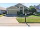 Two-story house with a green exterior, two-car garage, and a well-maintained lawn at 422 Troon Cir, Davenport, FL 33897