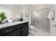 Modern bathroom with a walk-in shower, granite countertop, and dark vanity at 4322 Lana Ave, Davenport, FL 33897