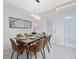 Elegant dining room with a wooden table, brown leather chairs, and modern lighting at 4322 Lana Ave, Davenport, FL 33897