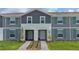Two-story townhome with gray siding, teal shutters, and a landscaped front yard at 4322 Lana Ave, Davenport, FL 33897