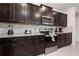 Well-equipped kitchen with dark wood cabinets and granite countertops at 4322 Lana Ave, Davenport, FL 33897