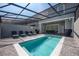 Private screened pool with lounge chairs and grill at 4322 Lana Ave, Davenport, FL 33897