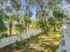 Spacious backyard with a white fence and mature trees providing shade at 5865 La Costa Dr # 216, Orlando, FL 32807