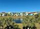 Community overview featuring lake, lush landscaping, and colorful homes at 8035 Surf St, Kissimmee, FL 34747