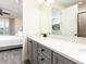 Double vanity bathroom with gray cabinets and a view into bedroom at 8035 Surf St, Kissimmee, FL 34747