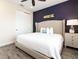 King-size bed, gray wood floors, and a navy feature wall at 8035 Surf St, Kissimmee, FL 34747