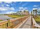 Wooden boardwalk winds through a waterfront community with colorful homes at 8035 Surf St, Kissimmee, FL 34747