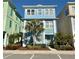Three-story light blue townhouse with palm trees at 8035 Surf St, Kissimmee, FL 34747