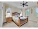 Elegant bedroom with wooden furniture, ceiling fan, and large windows offering natural light at 9301 Tibet Pointe Cir, Windermere, FL 34786