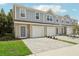 Three-unit townhome building with gray siding, attached garages, and paved driveways at 1215 Fan Palm Dr, Davenport, FL 33897