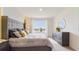Main bedroom with gray upholstered bed, dresser, and view at 1296 Hanoverian Dr, Lake Alfred, FL 33850