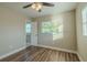 Bedroom with ceiling fan, wood floor, and access to bathroom at 1921 Rockwell Rd, Orlando, FL 32808