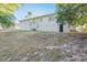 Back of house with a large yard and mature trees at 1921 Rockwell Rd, Orlando, FL 32808