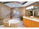 Bathroom with a jacuzzi tub, double vanity, and stone tile at 1925 S Atlantic Ave # 502, Daytona Beach, FL 32118