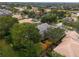 Aerial view of a home with a tile roof surrounded by trees and neighboring properties at 25510 High Hampton Cir, Sorrento, FL 32776