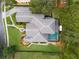 An aerial view showcasing the home's unique roofline, pool, and landscaping at 25510 High Hampton Cir, Sorrento, FL 32776