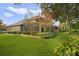 Spacious backyard with mature trees, landscaping, and screened patio at 25510 High Hampton Cir, Sorrento, FL 32776
