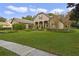 Elegant home with stone accents, lush landscaping, and a paved walkway at 25510 High Hampton Cir, Sorrento, FL 32776