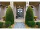 Welcoming front porch with double doors, decorative urns, and manicured shrubs at 25510 High Hampton Cir, Sorrento, FL 32776