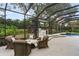 Screened pool area with seating, lush landscaping, and outdoor kitchen at 25510 High Hampton Cir, Sorrento, FL 32776