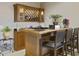 Home bar with granite countertop, wooden cabinets, wine rack, and bar seating at 25510 High Hampton Cir, Sorrento, FL 32776