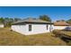 Rear view of the house showcasing the gray exterior and a covered patio at 1215 Atlantic Ct, Poinciana, FL 34759