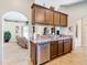 Kitchen with brown cabinets, stainless steel dishwasher, and double sink at 1218 Coda Ct, Dundee, FL 33838