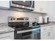 Stainless steel range and microwave in a white kitchen at 29 Hemlock Pass, Ocala, FL 34472