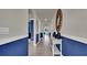 Long hallway with blue accent wall and decorative console table at 2952 Waterlily Way, Poinciana, FL 34759