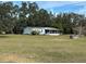 Mobile home with a yard and surrounding trees at 31029 Nocatee Trl, Sorrento, FL 32776