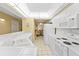 White kitchen with appliances and view into dining area at 4575 S Atlantic Ave # 6209, Ponce Inlet, FL 32127