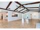 Spacious living room with wood beam ceiling, tile floor and view of the kitchen at 504 Birdsong Ct, Longwood, FL 32779