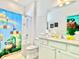 Super Mario-themed bathroom with fun shower curtain, colorful accessories, and tiled walls at 6234 Sand Skipper Rd, Orlando, FL 32821
