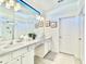 Bright, spacious bathroom featuring white cabinets, a large mirror, and tiled floors at 6234 Sand Skipper Rd, Orlando, FL 32821