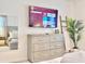 Modern bedroom featuring a large TV, dresser, and stylish decor elements at 6234 Sand Skipper Rd, Orlando, FL 32821
