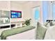 Cozy bedroom with a TV, shelves, and comfortable bed with green accents at 6234 Sand Skipper Rd, Orlando, FL 32821