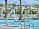 Resort-style pool with a chairlift, lounge chairs, and palm trees at 6234 Sand Skipper Rd, Orlando, FL 32821